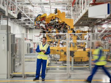 Industrial factory floor with automated machinery, emphasizing machine safety and pressure-sensitive safety mats in high-risk environments.