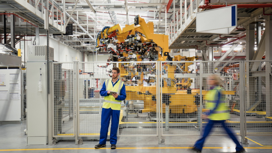 Industrial factory floor with automated machinery, emphasizing machine safety and pressure-sensitive safety mats in high-risk environments.