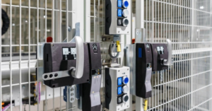 Interlock switches securing an access gate near hazardous machinery, ensuring the system remains inactive until the gate is closed.